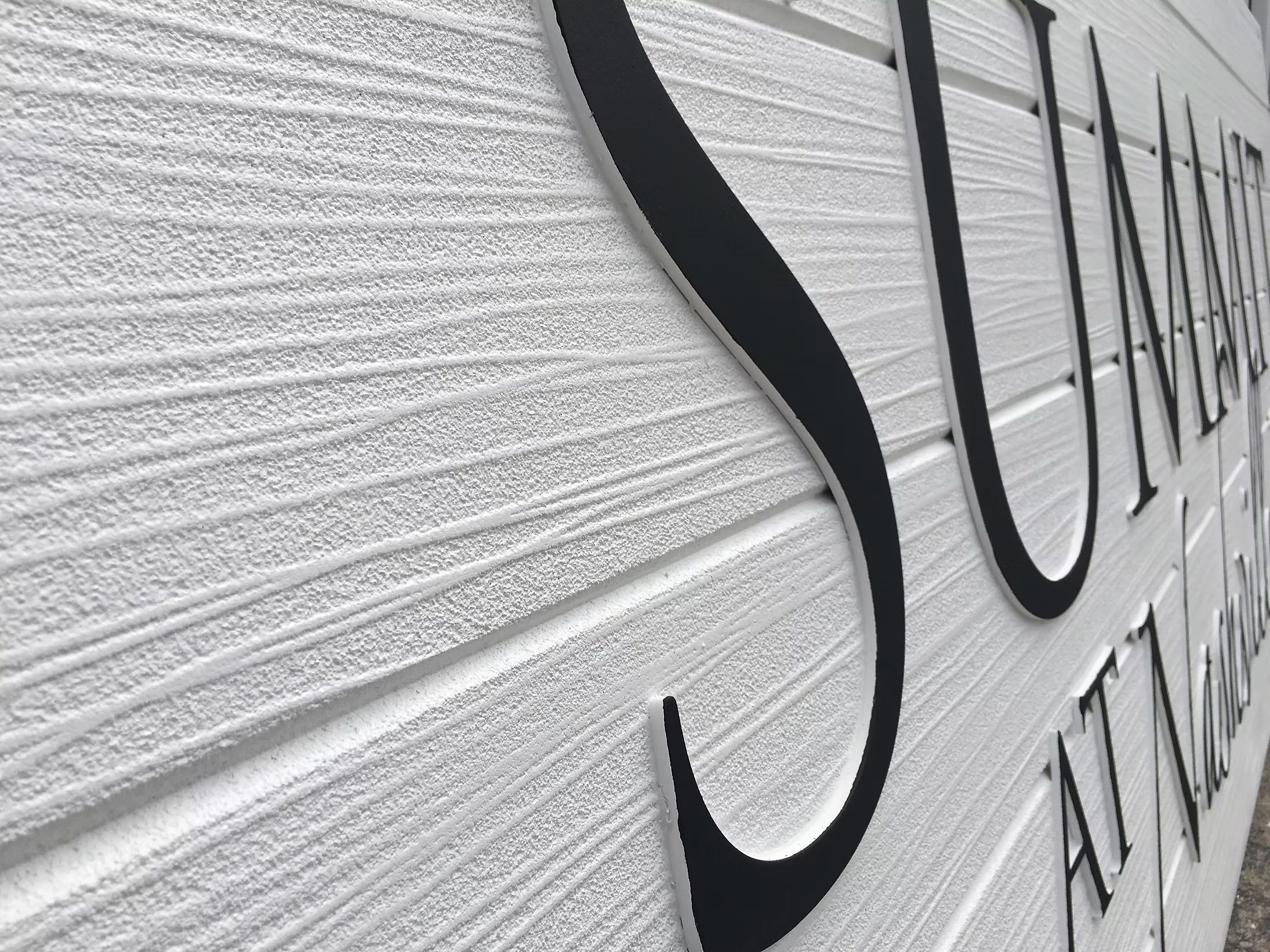 Close-up of woodgrain texture and dimensional lettering