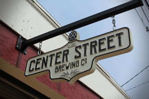 Double-sided hanging sign for a brewery storefront