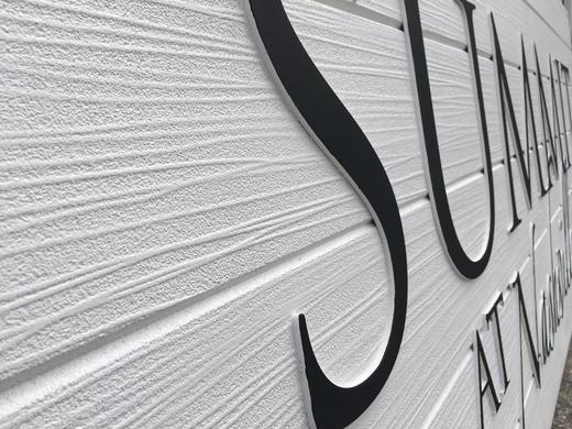 Close-up of woodgrain texture and dimensional lettering